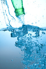 Obraz na płótnie Canvas Green bottle and water splashing
