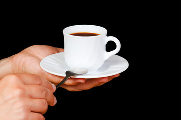 Hands with a cup of coffee on a black background