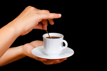 Hands with a cup of coffee on a black background