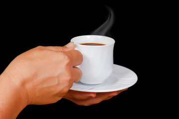 Hands with a cup of coffee with steam on a black background