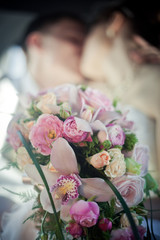 Kissing newlyweds with wedding bouquet