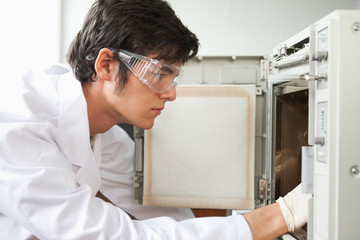 Close up of a scientist using a laboratory chamber furnace