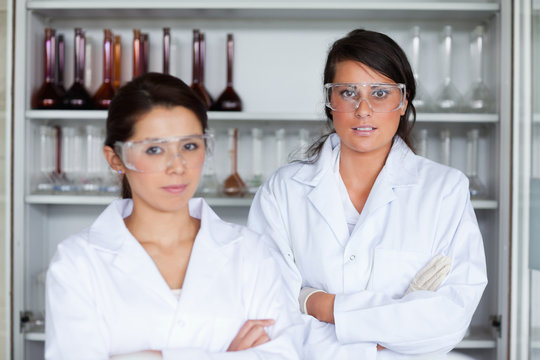 Serious female science students posing