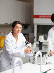 Portrait of a good looking science student using a microscope