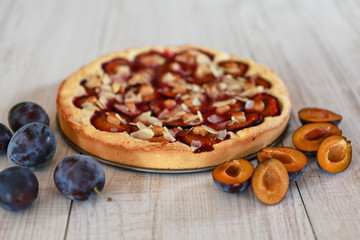 Plum pie and on a wooden white background