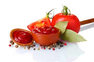 Ketchup in kom, kruiden en tomaten die op wit worden geïsoleerd