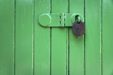 green wooden door rusty padlock