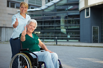 Fototapeta na wymiar Wózku inwalidzkim pokazuje z kciuki do góry