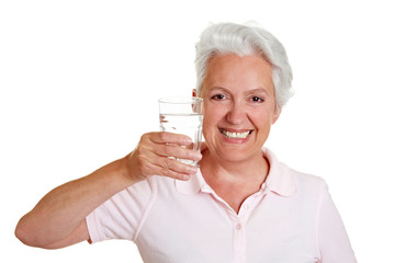 Seniorin hält Wasserglas