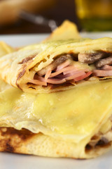 Rolled crepes filled with ham, cheese and mushroom