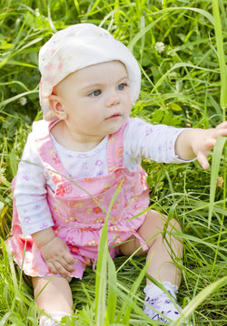 Curious baby girl on grass
