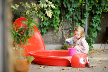 Adorable little girl playing in a sandbox