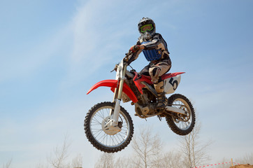 Naklejka premium Motocross motorbike racer performs a jump efficient
