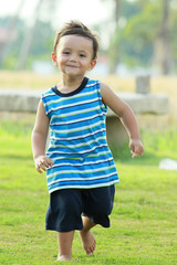 active young boy smiling and running