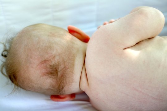 b&eacute;b&eacute; nu de dos allong&eacute; sur le cot&eacute;