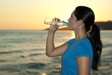Profile of woman drinking water on the beach