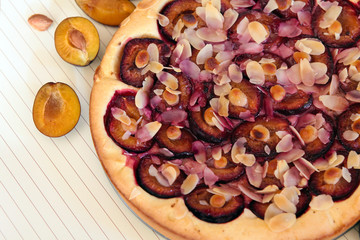 Plum pie and plums on a wooden white background