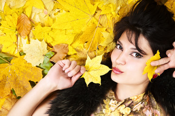 Portrait woman with autumn yellow leaves are on the background.