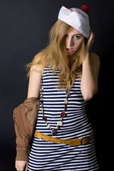 Naklejka premium Attractive young lady in sailor dress and hat in studio on the b