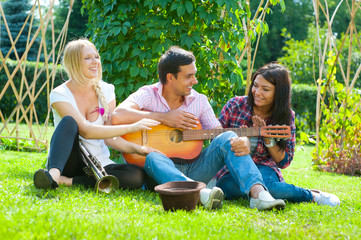 Young friends play the guitar and trumpet