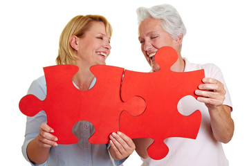 Frauen halten rotes Puzzle