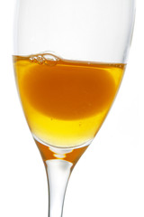 Fresh egg with yolk on transparent glass.