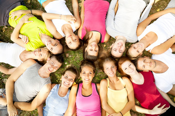 friends happy group in circle together on grass