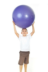 Boy holding big ball over head