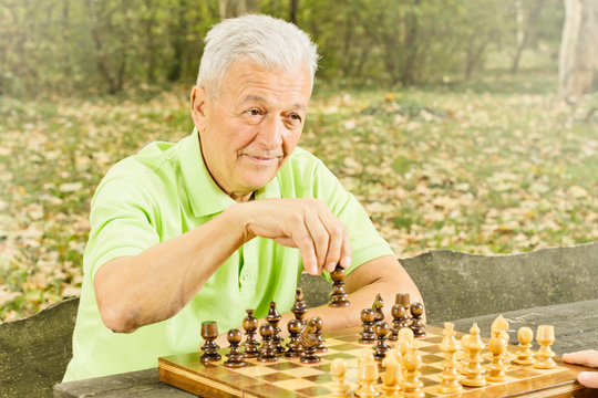 Elderly Man Playing Chess In The Park