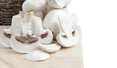 Fresh champignon mushrooms in rustic basket isolated on white