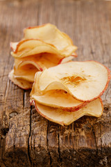 dried apples slices on old wooden table stacked, shallow dof