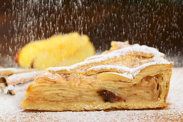 Sieving sugar powder over a slice of delicious apple pie