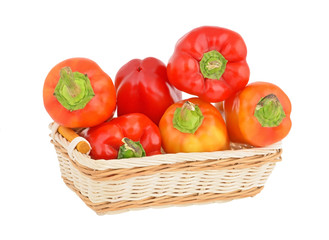Fototapeta na wymiar Fresh sweet red pepper in a wattled basket on white