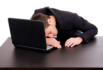 Tired young businessman sleeping on desk, isolated on white