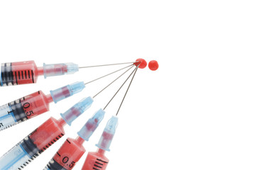 Syringes with blood drop over white