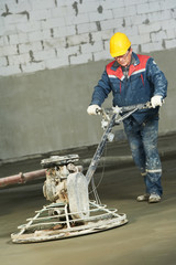 Worker trowelling and finishing of concrete
