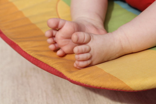 Newborn Baby Feet On A Rainbow Background