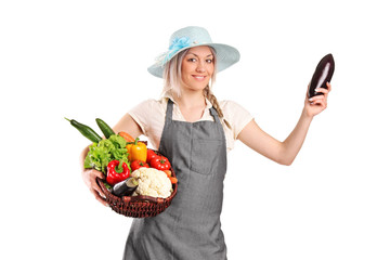Smiling female farmer holding various vegetables