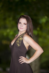 lächelnde hübsche junge Frau in braunem Kleid