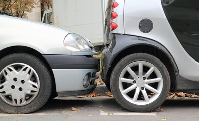 Two cars parallel parked less than an inch from each other.