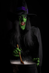 Witch stirring her misty cauldron, black background.