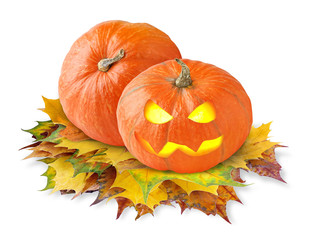 Isolated pumpkins. Two orange Halloween pumpkin heads with glowing eyes over pile of yellow autumn leaves isolated on white background