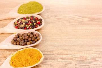 spices in the spoons on wooden background