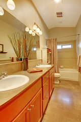 Bathroom with two white sinks and maple cabinets