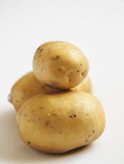 bunch of potatoes on white background close up shoot