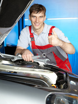 Satisfied master mechanic shows thump up for a good job