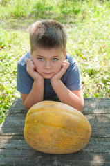 Fototapeta premium A boy with a large melon in his hands
