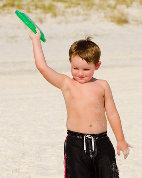 Young boy playing Frisbee on beach