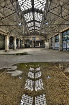Abandoned old industrial building with reflection in a puddle
