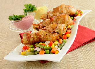 Roast chicken leg wrapped in bacon with vegetables